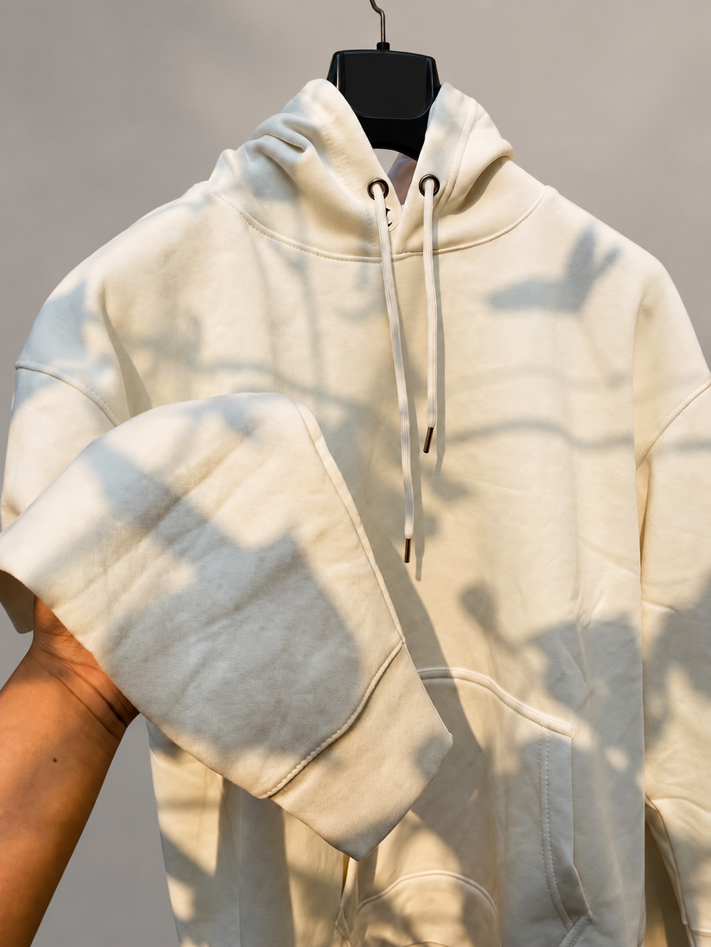 Cream hoodie showing the sleeve, pocket and hood